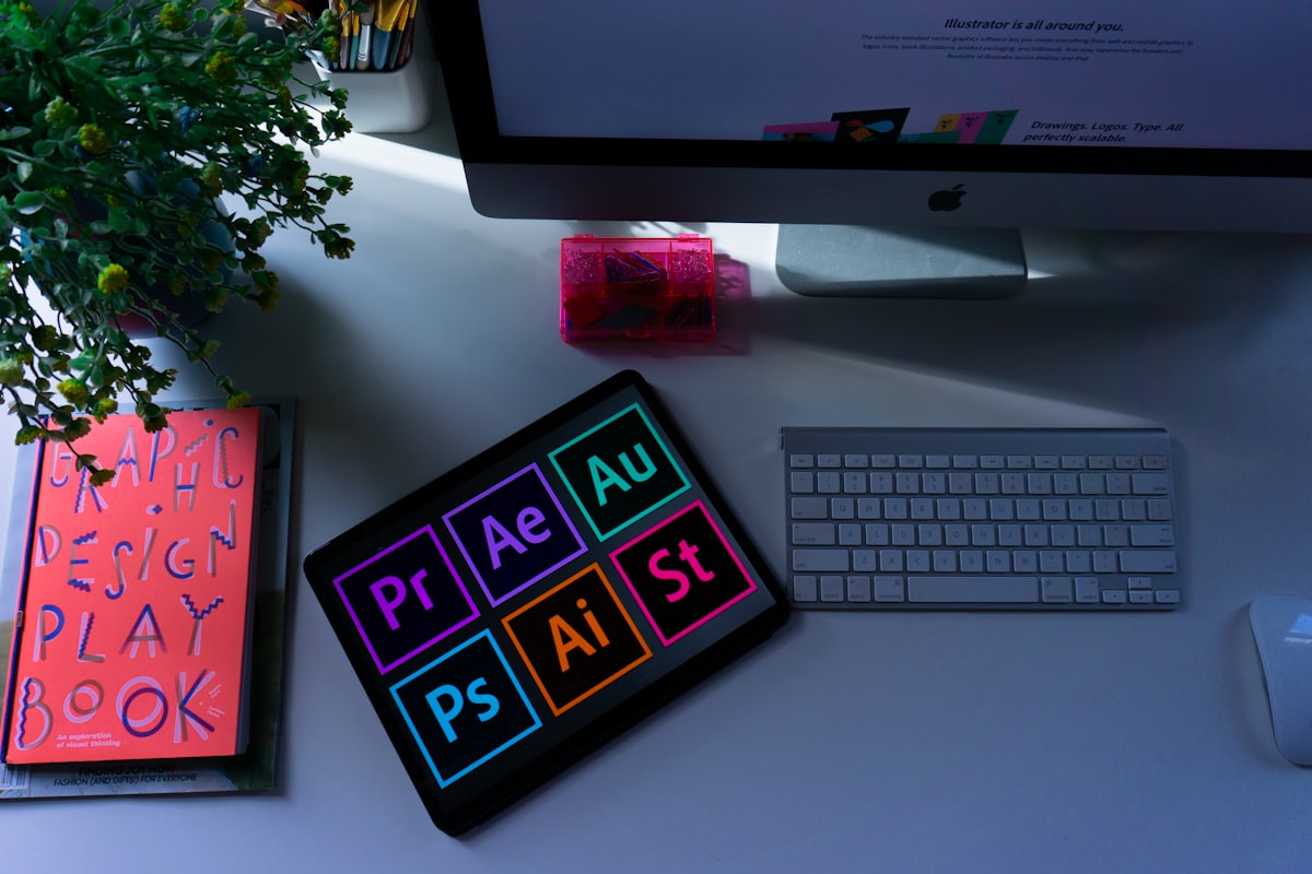 A creative desk flatlay with a keyboard, notebook and colour swatches.