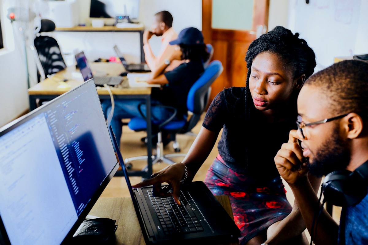 Two developers reviewing code together at a workstation.