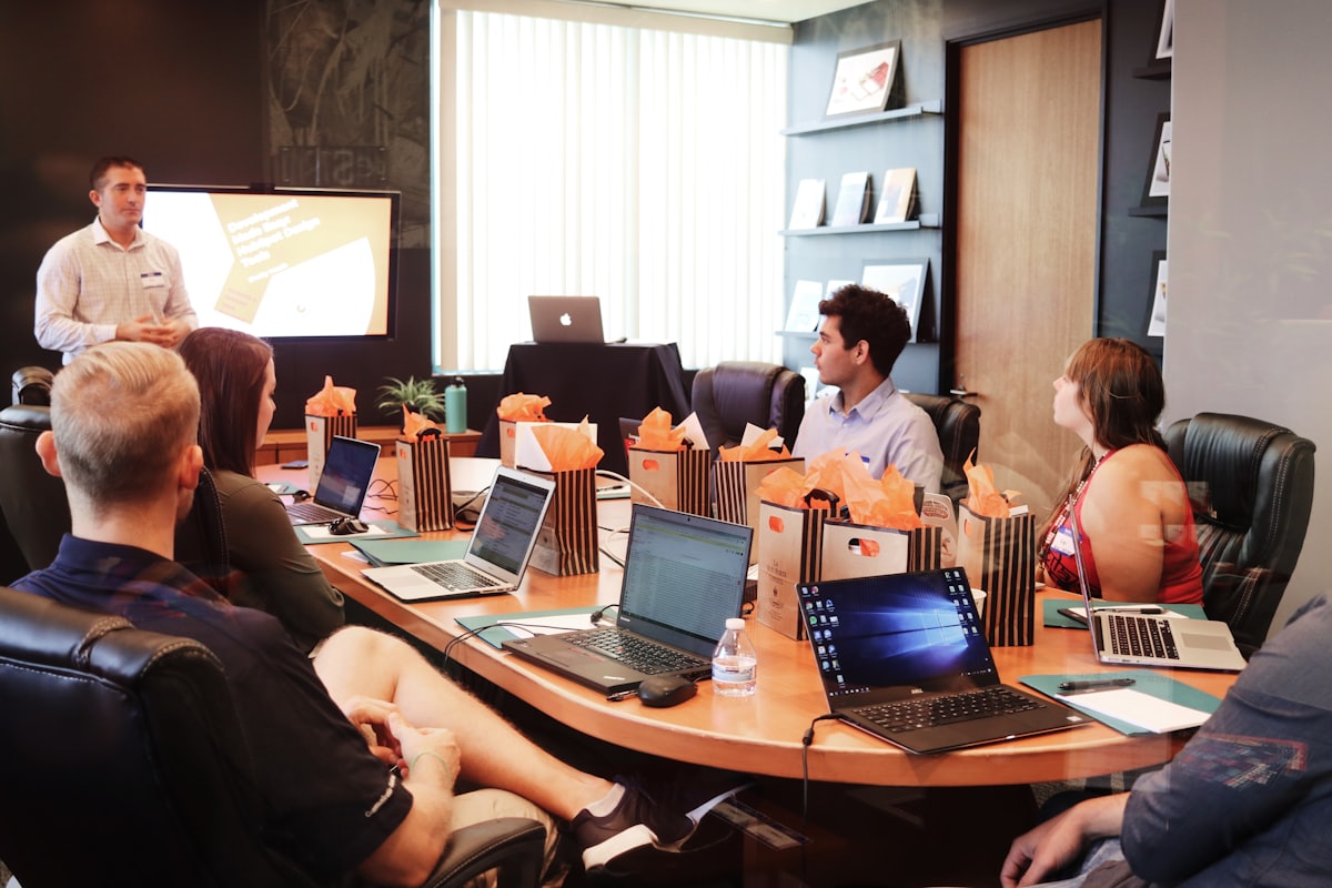 A group of people attending a working session with laptops open.