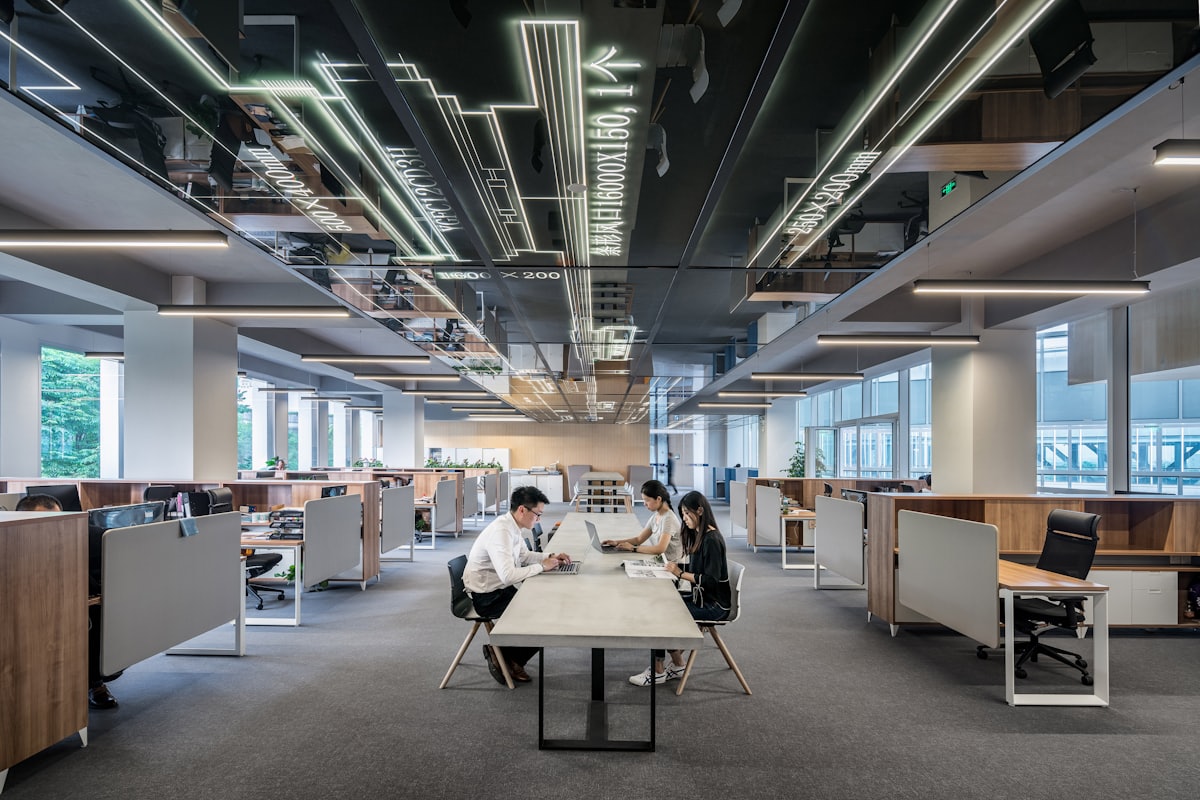 A bright open-plan studio office with desks and plants.