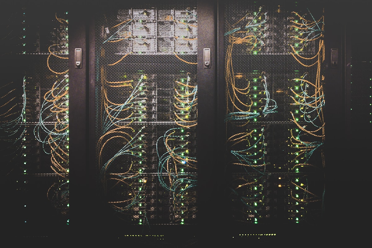 Rows of illuminated server racks in a dark data centre.