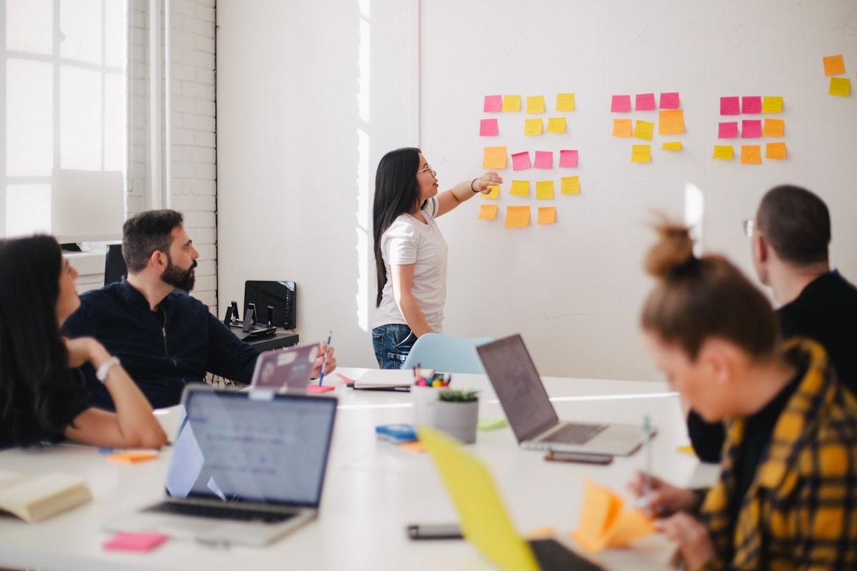 Colleagues in a workshop arranging sticky notes on a wall.